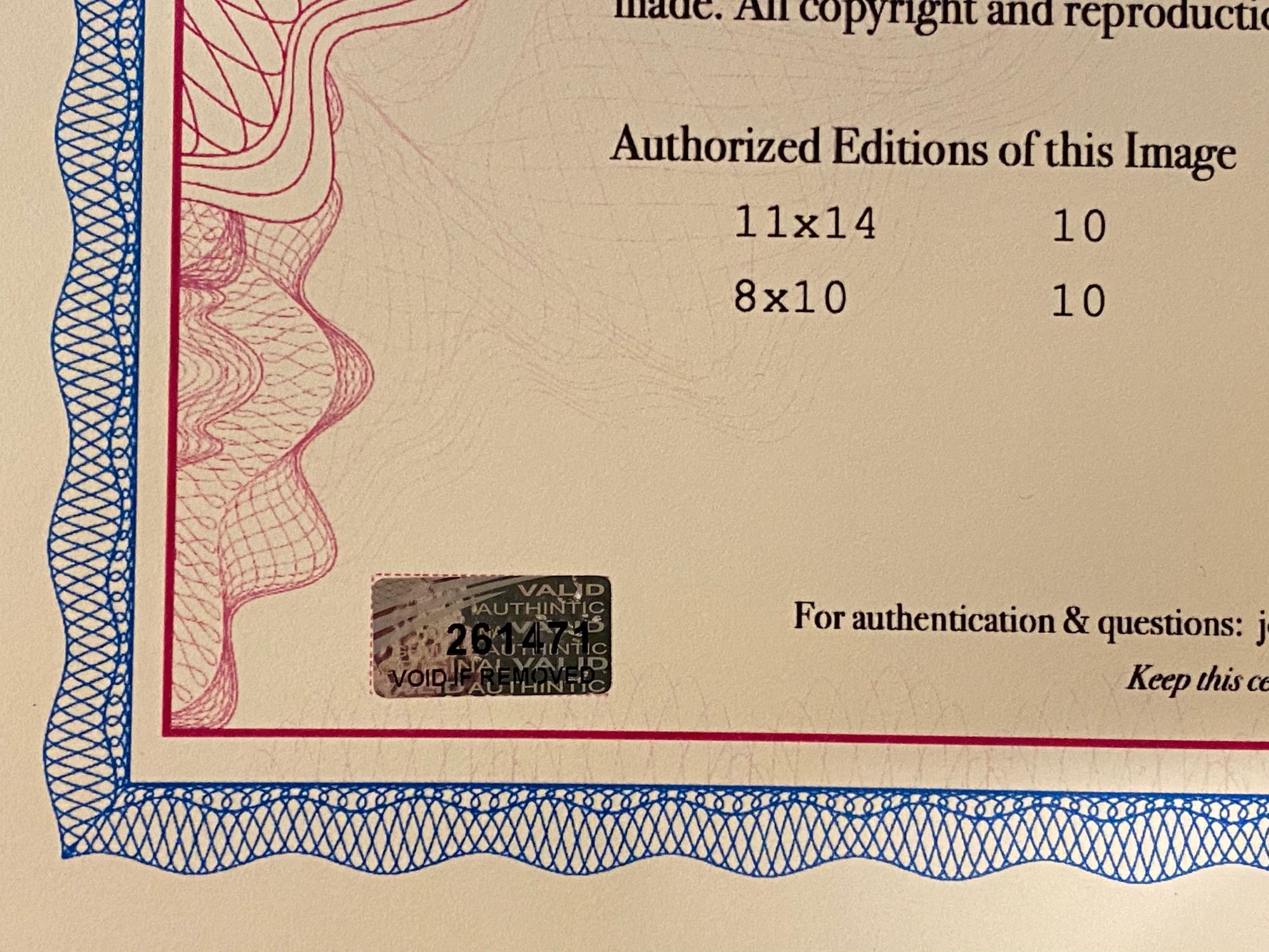 A closeup of the lower left part of my certificate of authenticity with a holographic sticker affixed.